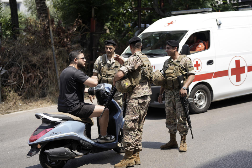 Lebanese soldiers speak to a motorcyclist as they stand guard on a road that leads to the U.S. Embassy in Aukar, northern suburb of Beirut, Lebanon, Wednesday, June 5, 2024. A gunman was captured by Lebanese soldiers after attempting to attack the U.S. Embassy near Beirut on Wednesday, the military said. (AP Photo/Hassan Ammar)