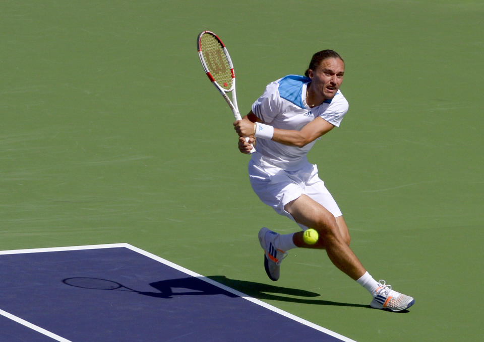 Alexandr Dolgopolov, of Ukraine, returns a shot to Roger Federer, of Switzerland, during their semifinal match at the BNP Paribas Open tennis tournament, Saturday, March 15, 2014, in Indian Wells, Calif. (AP Photo/Mark J. Terrill)