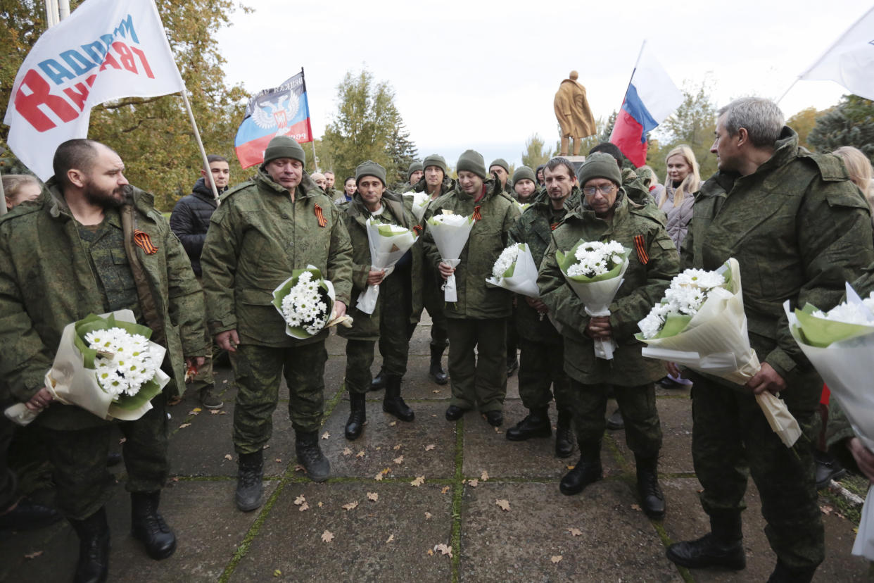 People greet 14 prisoners released by Ukraine as a prisoner swap, in Novoazovsk, separatist Donetsk People's Republic, eastern Ukraine, Friday, Oct. 21, 2022. (AP Photo/Alexei Alexandrov)