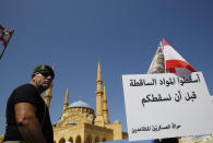 A retired Lebanese soldier protests near the parliament building where lawmakers and ministers are discussing the draft 2019 state budget, in Beirut, Lebanon, Tuesday, July 16, 2019. The lawmakers have begun discussing the draft 2019 state budget amid tight security and limited protests against proposed austerity measures. The proposed budget aims to avert a financial crisis by raising taxes and cutting public spending in an effort to reduce a ballooning deficit. (AP Photo/Hussein Malla)