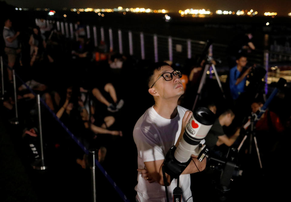 <p>Astronomy enthusiasts wait to see the lunar eclipse of a blood moon at Marina South Pier in Singapore July 28, 2018. REUTERS/Edgar Su </p>