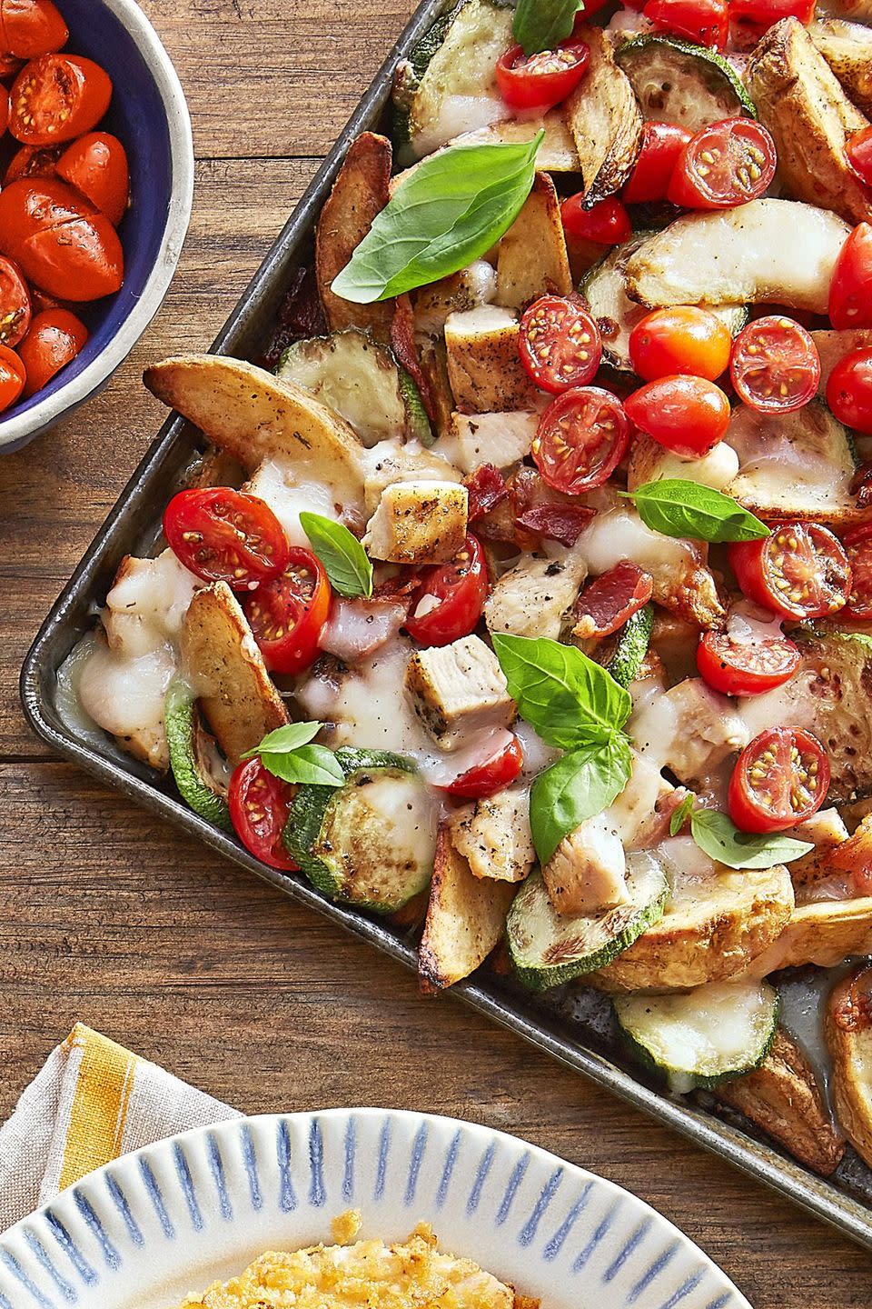 italian potato wedge nachos on a sheet tray and topped with fresh parsley leaves