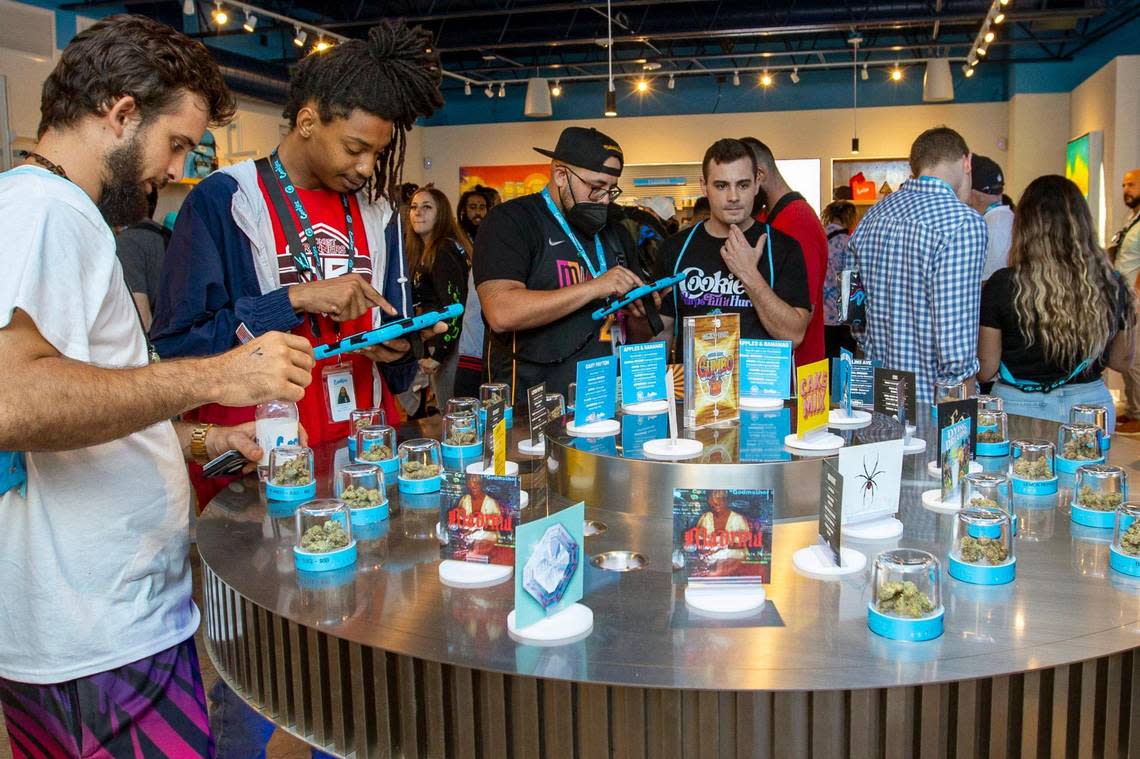 Customers and budtenders look over different strains of marijuana during the grand opening of Cookies Miami, Florida’s first minority-owned marijuana dispensary, in Miami on Saturday, Aug. 13, 2022. Daniel A. Varela/dvarela@miamiherald.com