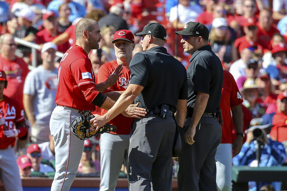 Cincinnati Reds' Joey Votto, left, argues with the umpires after being ejected after the first inning of a baseball game against the St. Louis Cardinals, Sunday, Oct. 1, 2023, in St. Louis. (AP Photo/Scott Kane)