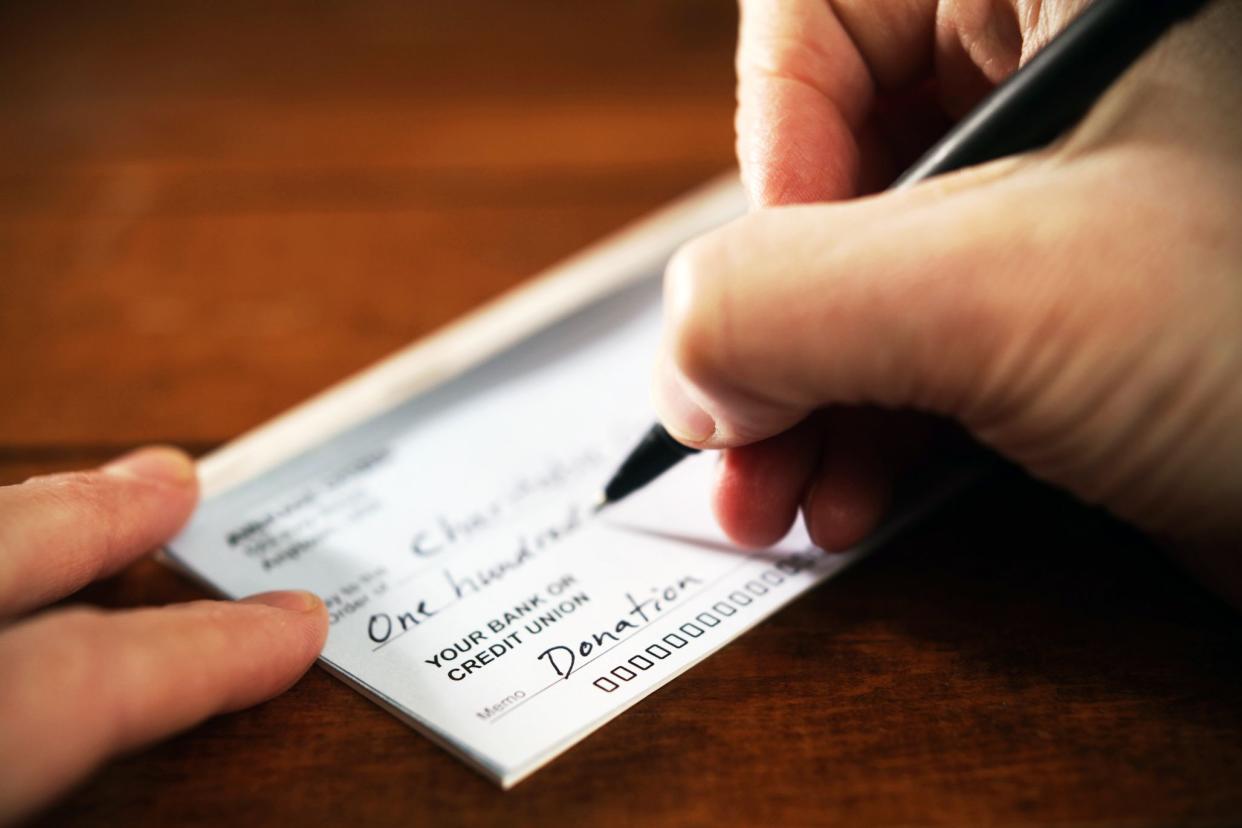 close-up of hand writing donation check