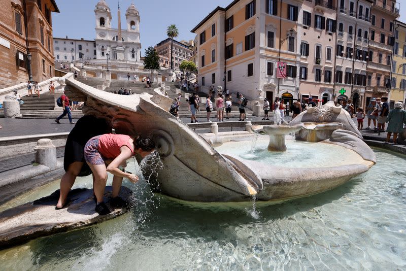 La gente se refresca cerca de la Plaza de España, durante una ola de calor en Italia, mientras se espera que las temperaturas aumenten aún más en los próximos días, en Roma, Italia