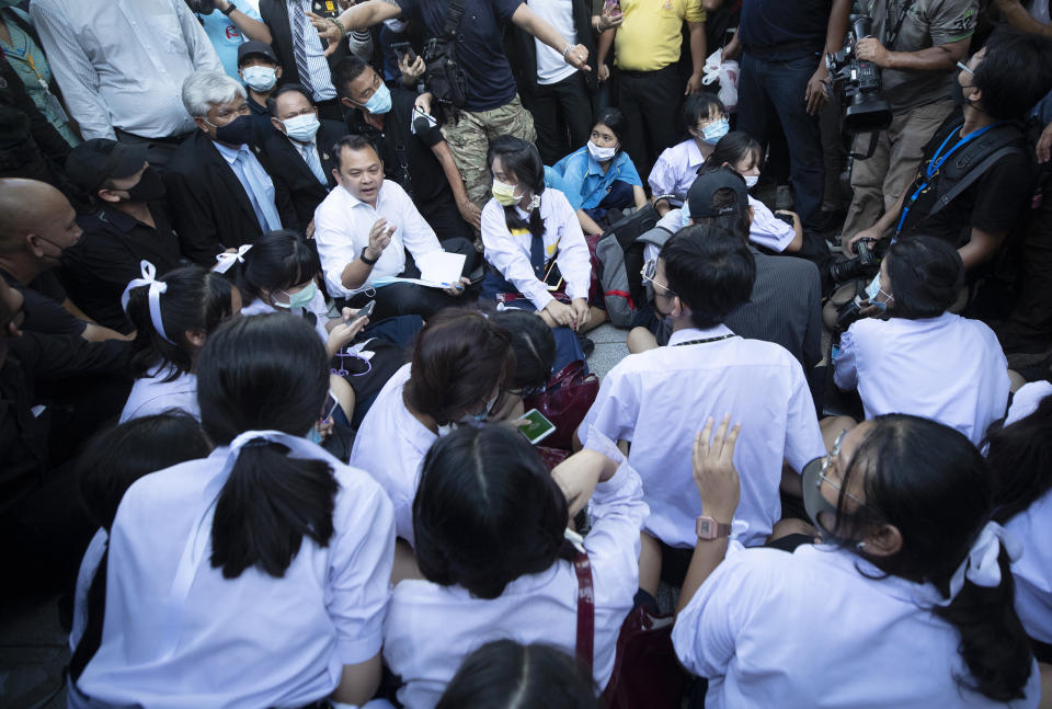 Thai Education Minister Nataphol Teepsuwan, center left in white shirt, talks to pro-democracy students during a protest rally in front of Education Ministry in Bangkok, Thailand, Wednesday, Aug. 19, 2020. Student protesters have stepped up pressure on the government with three core demands: holding new elections, amending the constitution and ending the intimidation of critics of the government. (AP Photo/Sakchai Lalit)