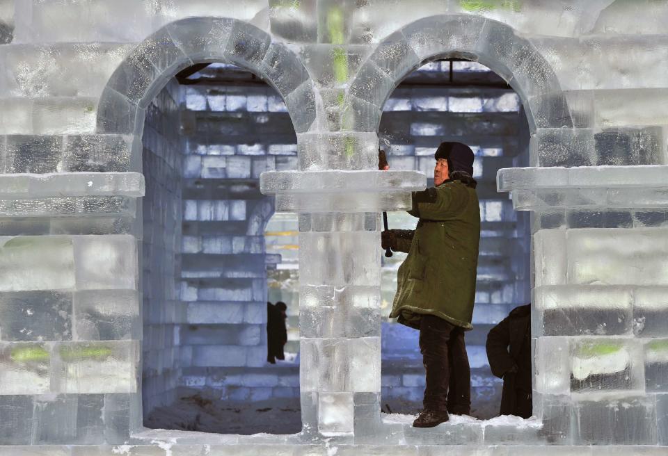 A worker polishes an ice sculpture ahead of the 30th Harbin Ice and Snow Festival, in Harbin, Heilongjiang province December 27, 2013. According to the festival organizers, nearly 10,000 workers were employed to build the ice and snow sculptures, which require about 180,000 square metres of ice and 150,000 square metres of snow. The festival kicks off on January 5, 2014. REUTERS/Sheng Li (CHINA - Tags: ENVIRONMENT SOCIETY BUSINESS EMPLOYMENT TRAVEL) CHINA OUT. NO COMMERCIAL OR EDITORIAL SALES IN CHINA