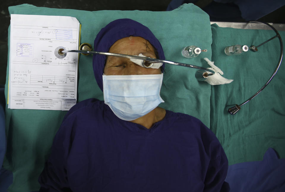 A patient lies on a hospital bed after receiving anesthesia before cataract surgery at the Tilganga Eye Center in Kathmandu, Nepal, March 26, 2021. Nepal’s “God of Sight” eye doctor renowned for his innovative and inexpensive cataract surgery for the poor is taking his work beyond the Himalayan mountains to other parts of the world so there is no more unnecessary blindness in the world. Dr. Sanduk Ruit, who has won many awards for his work and performed some 130,000 cataract surgery in the past three decades, is aiming to expand his work beyond the borders of his home country and the region to go globally. (AP Photo/Niranjan Shrestha)