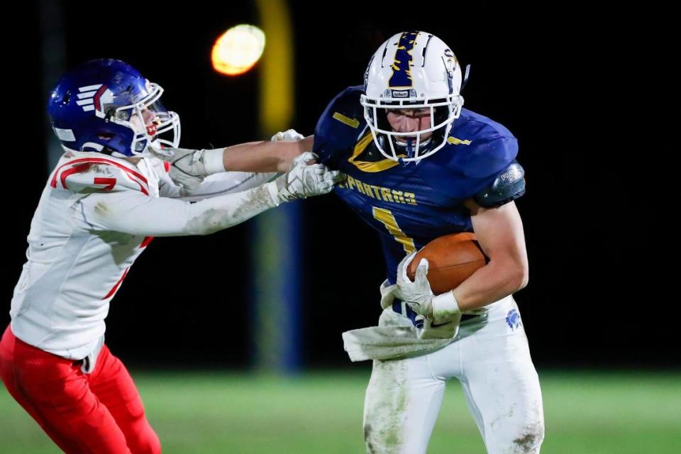 Sayre’s Charlie Slabaugh (1) stiff arms Eminence’s Austin Bright while running the ball during their game at the Sayre Athletic Complex on Friday.