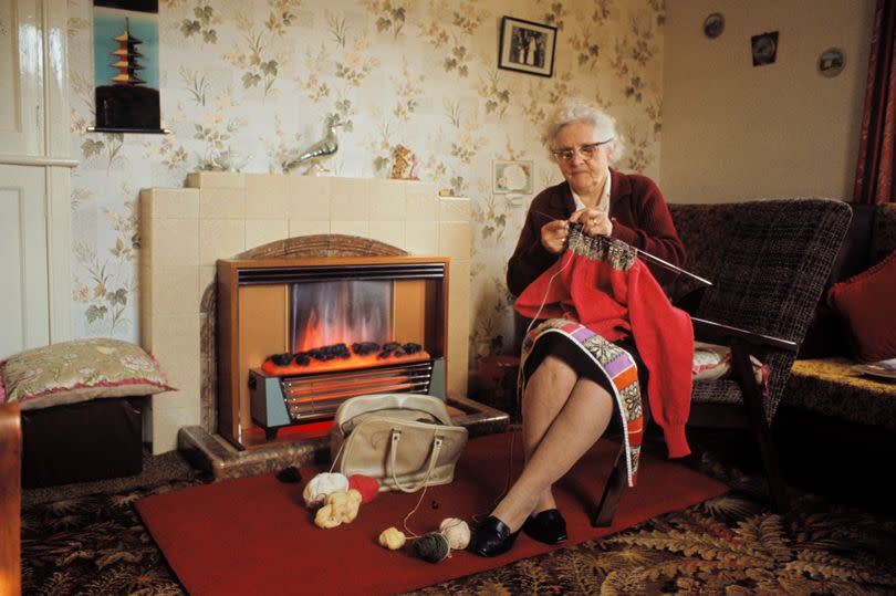 SHETLAND ISLANDS, SCOTLAND - 1st JUNE: View of an elderly woman knitting a Fair Isle style jumper by a gas fire in the living room of a cottage on one of the Shetland Islands in June 1970. (Photo by Chris Morphet/Redferns)