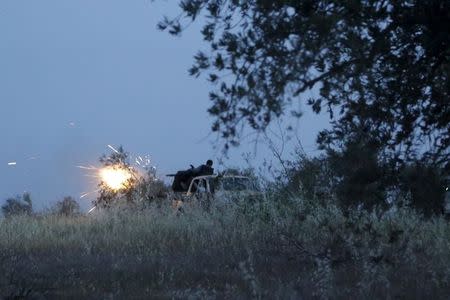 Rebel fighters of the Al-Furqan brigade fire their weapon during what they said is an offensive to take control of the al-Mastouma army base which is controlled by forces loyal to Syria's President Bashar al-Assad near Idlib city May 17, 2015. Picture taken May 17, 2015. REUTERS/Khalil Ashawi