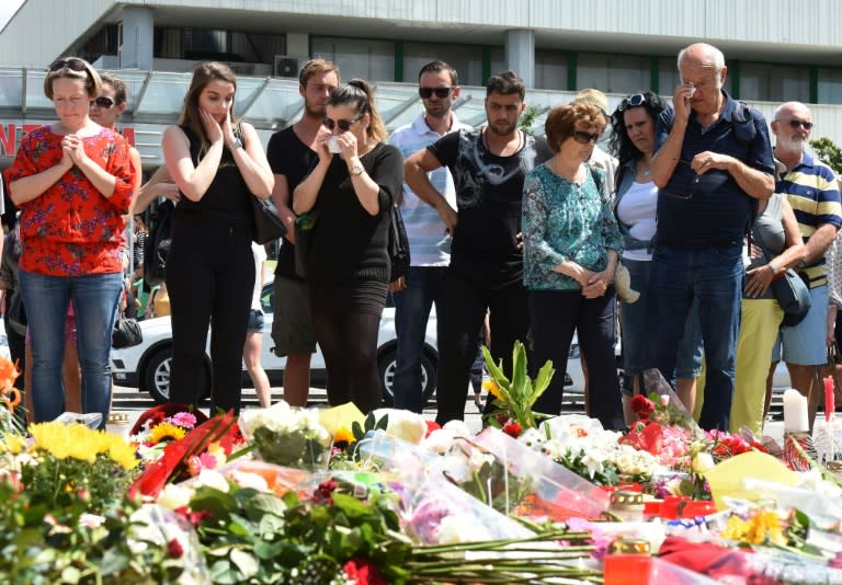 People in front of the Olympia Einkaufszentrum shopping centre in Munich mourn those killed there in a shooting rampage