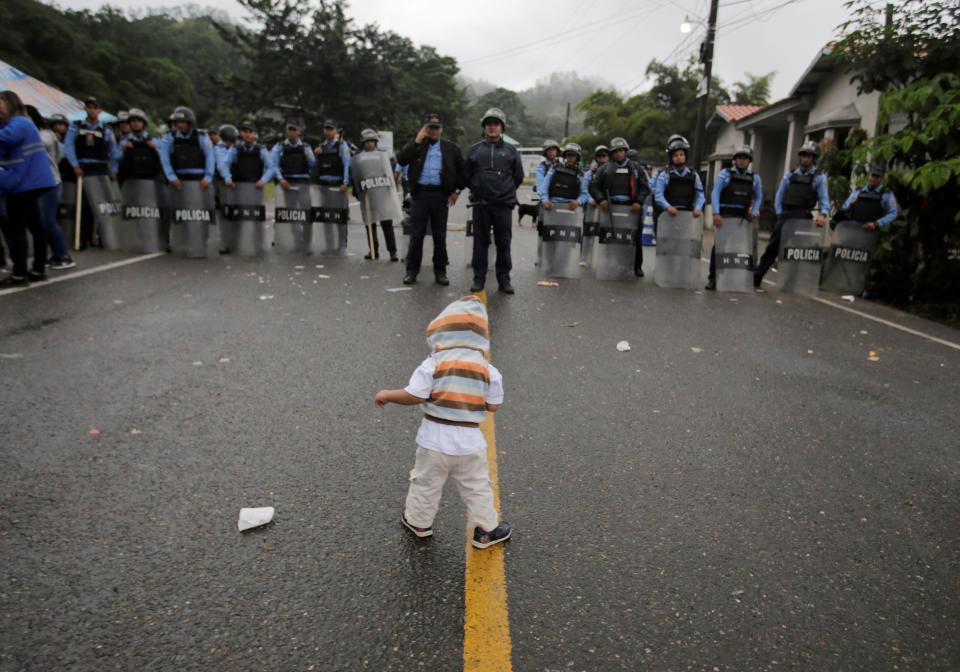 A young migrant child is confronted by police.