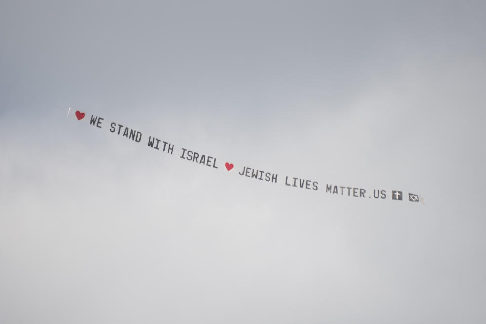 A plane bearing a banner that reads ""We stand with Israel jewishlivesmatter.us" flies overhead before the University of Michigan's Spring 2024 Commencement Ceremony at Michigan Stadium in Ann Arbor, Mich., on Saturday, May 4, 2024. (Katy Kildee/Detroit News via AP)