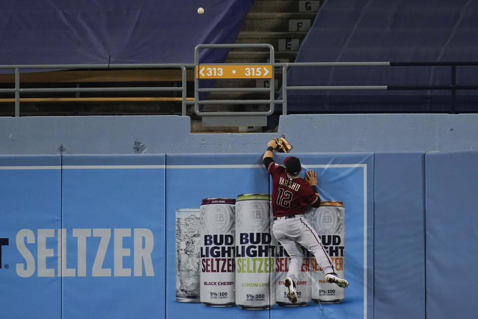 Arizona Diamondbacks center fielder Daulton Varsho leaps for but can't catch a solo home run by Los Angeles Dodgers' Mookie Betts during the ninth inning of a baseball game Wednesday, Sept. 2, 2020, in Los Angeles. (AP Photo/Marcio Jose Sanchez)