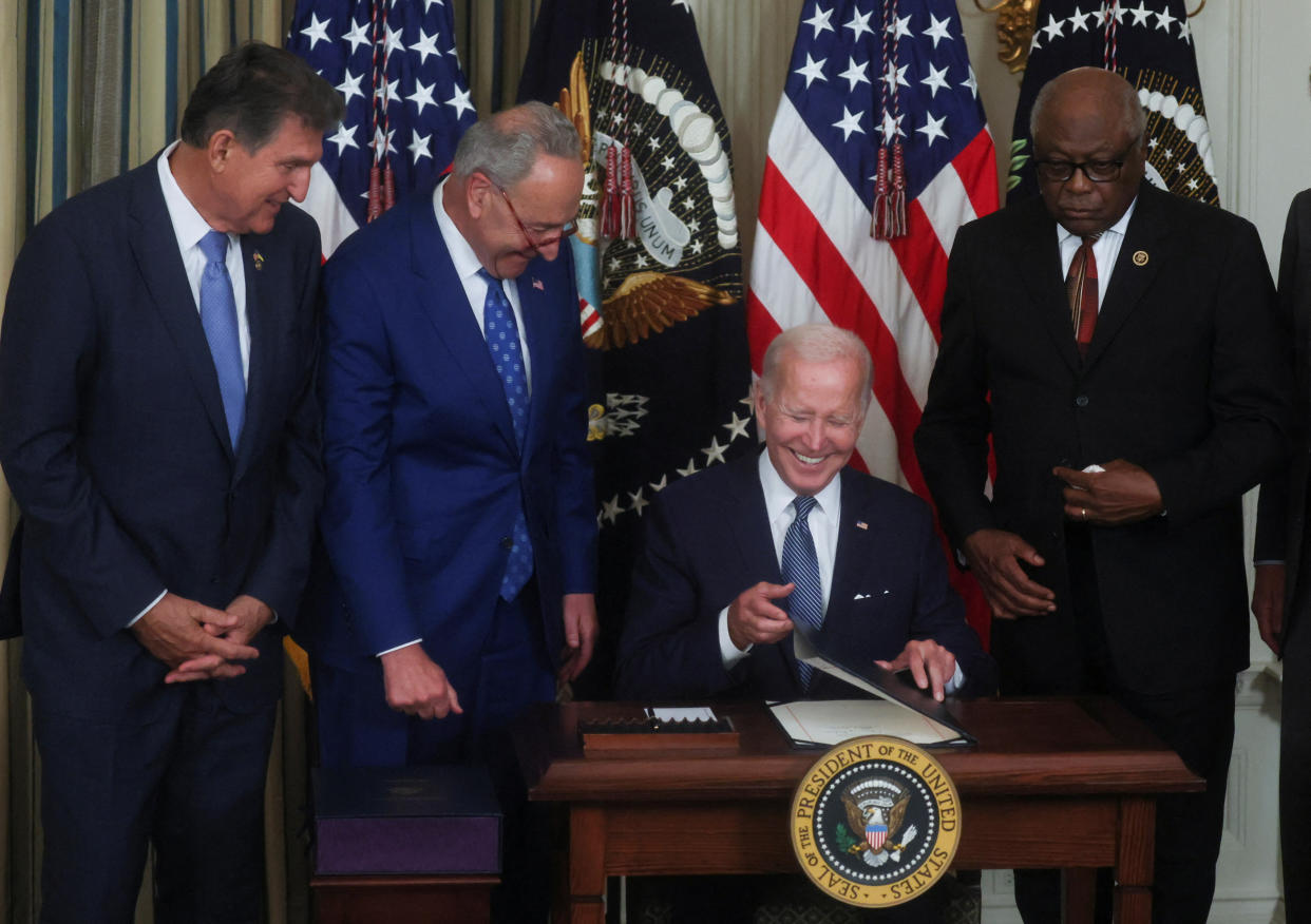 U.S. President Joe Biden smiles with U.S. Senator Joe Manchin (D-WV), Senate Majority Leader Chuck Schumer (D-NY) and U.S. House Majority Whip James Clyburn (D-SC) as he signs 