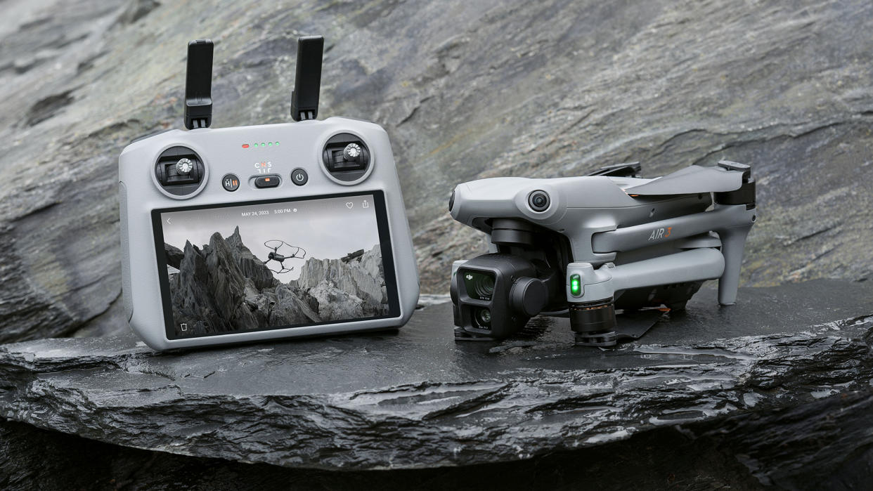  DJI Air 3 drone in folded position on a rock, alongside RC2 controller 