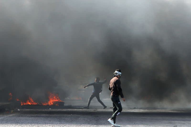 Iraqi demonstrators burn tires during ongoing anti-government protests in Basra