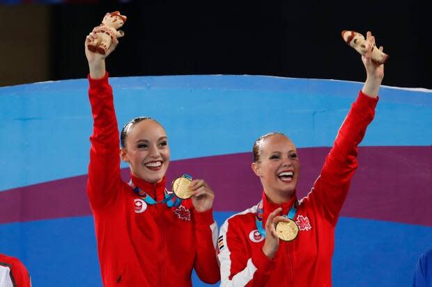 Jacqueline Simoneau, right, and Claudia Holzner, of Canada, celebrate after receiving their gold medals in the artistic swimming duet free routine finals at the Pan American Games in Lima, Peru on July 31, 2019. (Moises Castillo/The Associated Press - image credit)