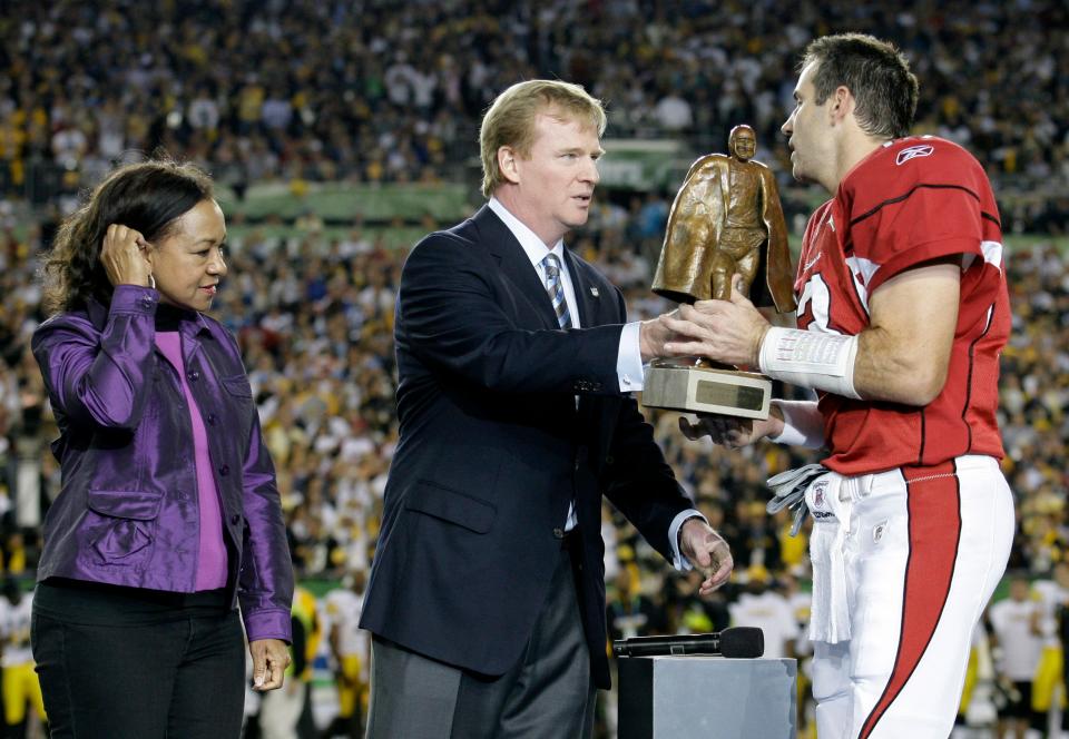 NFL Commissioner Roger Goodell (center) presents the Walter Payton Man of the Year award to Arizona Cardinals quarterback Kurt Warner before the NFL Super Bowl XLIII football game on Feb. 1, 2009, in Tampa, Fla. Payton's widow, Connie, looks on.