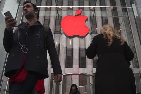 The Apple logo is illuminated in red at the Apple Store on 5th Avenue to mark World AIDS Day, in the Manhattan borough of New York December 1, 2014. REUTERS/Carlo Allegri