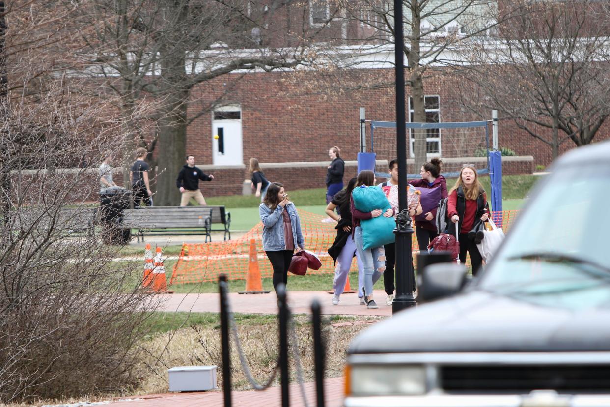 A flow of people carrying bags and crates left University of Delaware dorms on March 20, 2020, after the school suspended in-person classes following the first positive case of coronavirus in the state.