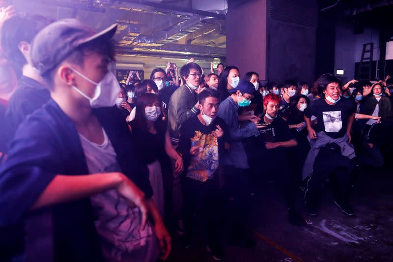 Fans wearing protective masks enjoy a band's performance at Hidden Agenda: This Town Needs (TNN) Live House during the club's last concert as business plummets due to the fear of the coronavirus, in Hong Kong