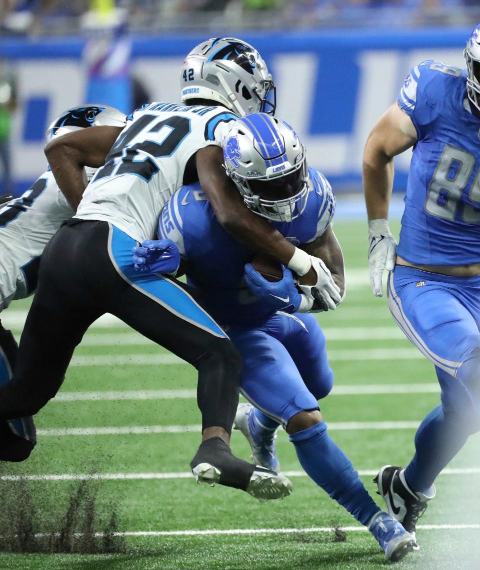Detroit Lions running back David Montgomery (5) is tackled by Carolina Panthers safety Sam Franklin Jr. (42) during first-half action at Ford Field in Detroit on Sunday, Oct, 8, 2023.