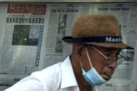 A man leaves after reading a newspaper with a photo of a plane carrying U.S. House Speaker Nancy Pelosi lands at Songshan Airport in Taipei, Taiwan with a headline reporting "Our series of military exercises are aimed at Pelosi channeling Taiwan" at a stand in Beijing, Wednesday, Aug. 3, 2022. After weeks of threatening rhetoric, China stopped short of any direct military confrontation with the U.S. over the visit of Pelosi to Taiwan. (AP Photo/Andy Wong)