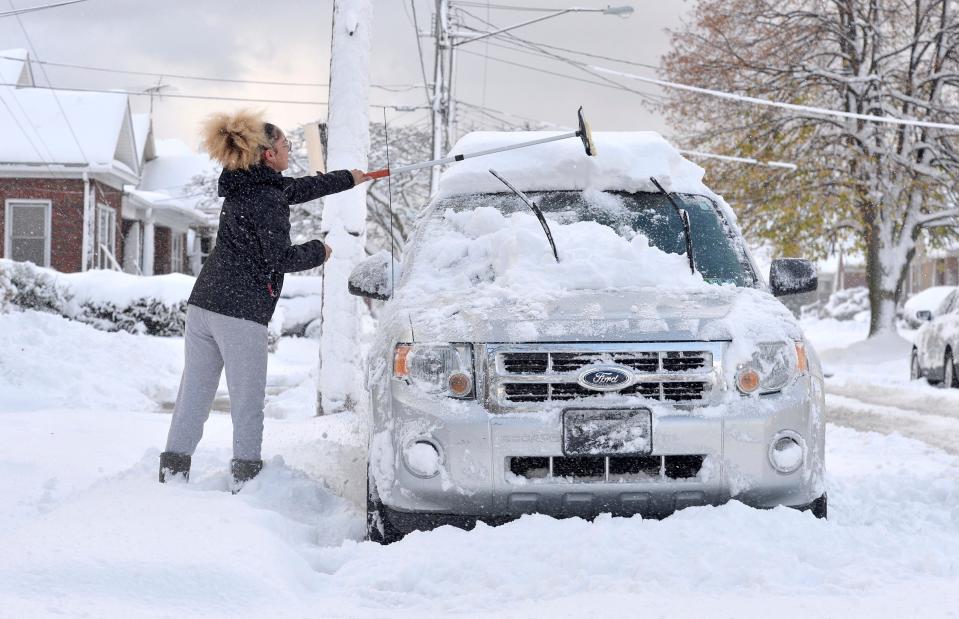 Taylor Olson clears snow from her car in the 400 block of East 33rd Street in Erie on Nov. 17, 2022.