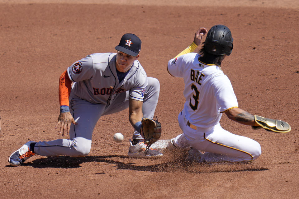 Houston Astros shortstop Jeremy Pena, left, waits for the late throw from catcher Yainer Diaz as Pittsburgh Pirates' Ji Hwan Bae (3) slides safely into second with a stolen base during the third inning of a baseball game in Pittsburgh, Wednesday, April 12, 2023. (AP Photo/Gene J. Puskar)
