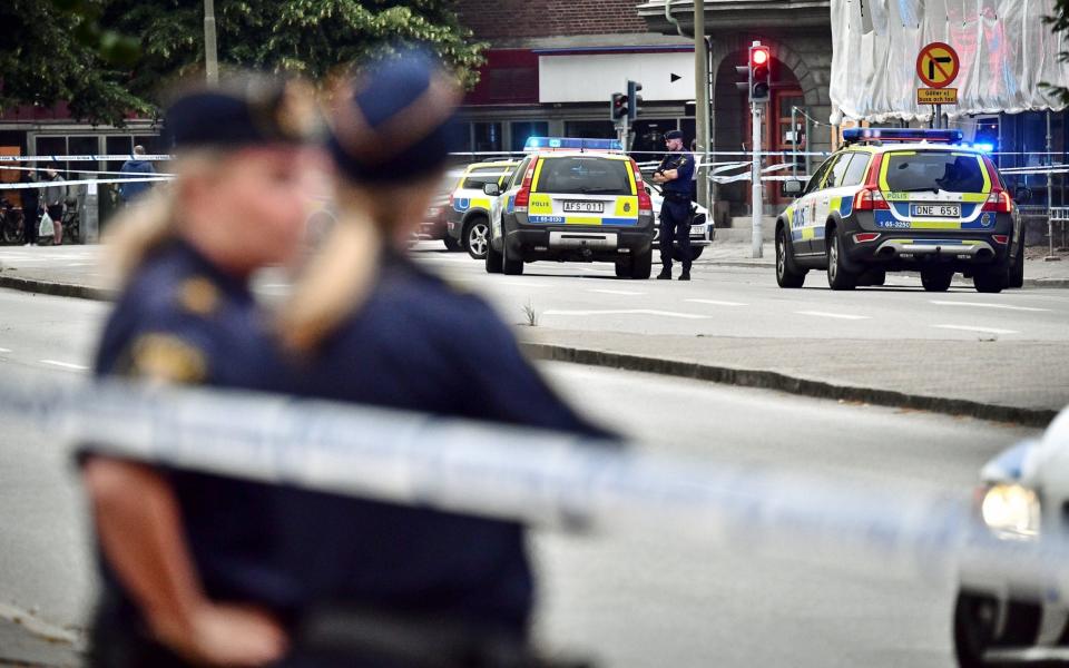 Police stand next to a cordon after a shooting on a street in central Malmo - REUTERS