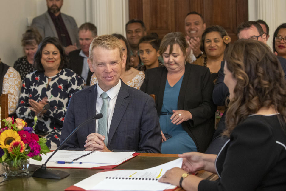 Chris Hipkins, center left, is sworn in as New Zealand's next prime minister by Governor-General Dame Cindy Kiro, right, at Government House in Wellington, Wednesday, Jan. 25, 2023. Hipkins, 44, has promised a back-to-basics approach focusing on the economy and what he described as the "pandemic of inflation." (Mark Mitchell/New Zealand Herald via AP)