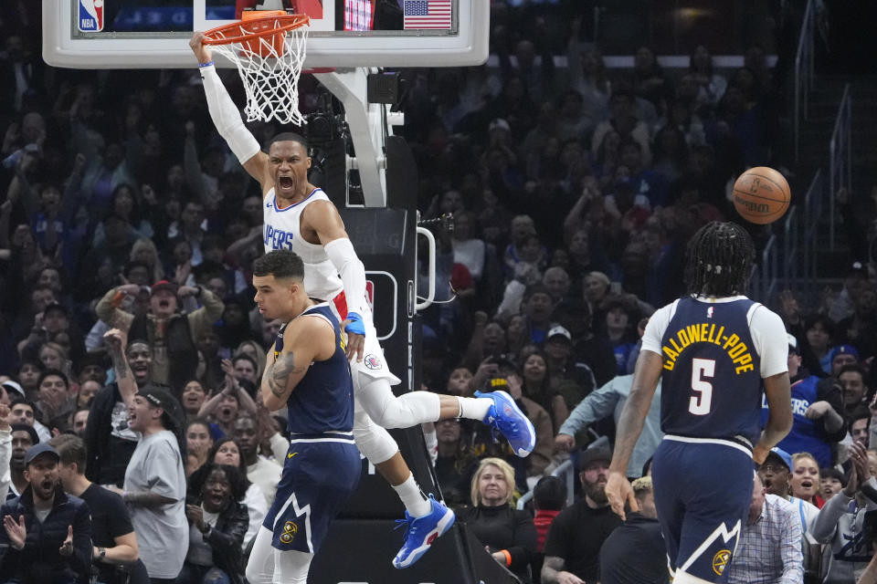 Los Angeles Clippers guard Russell Westbrook, upper left, celebrates after dunking as Denver Nuggets forward Michael Porter Jr., lower left, and guard Kentavious Caldwell-Pope defend during the first half of an NBA basketball game Thursday, April 4, 2024, in Los Angeles. (AP Photo/Mark J. Terrill)