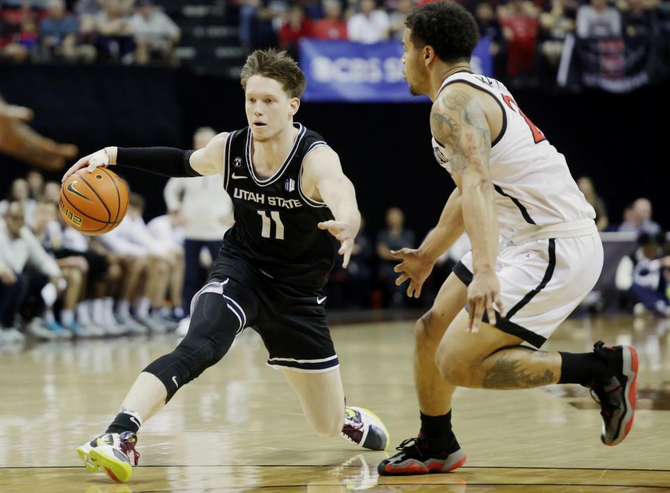 Utah State Aggies guard Max Shulga dribbles