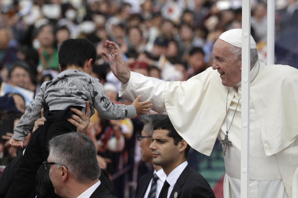 Pope Francis caresses a child as he arrives for a Mass at a baseball stadium Sunday, Nov. 24, 2019, in Nagasaki, Japan. (AP Photo/Gregorio Borgia)