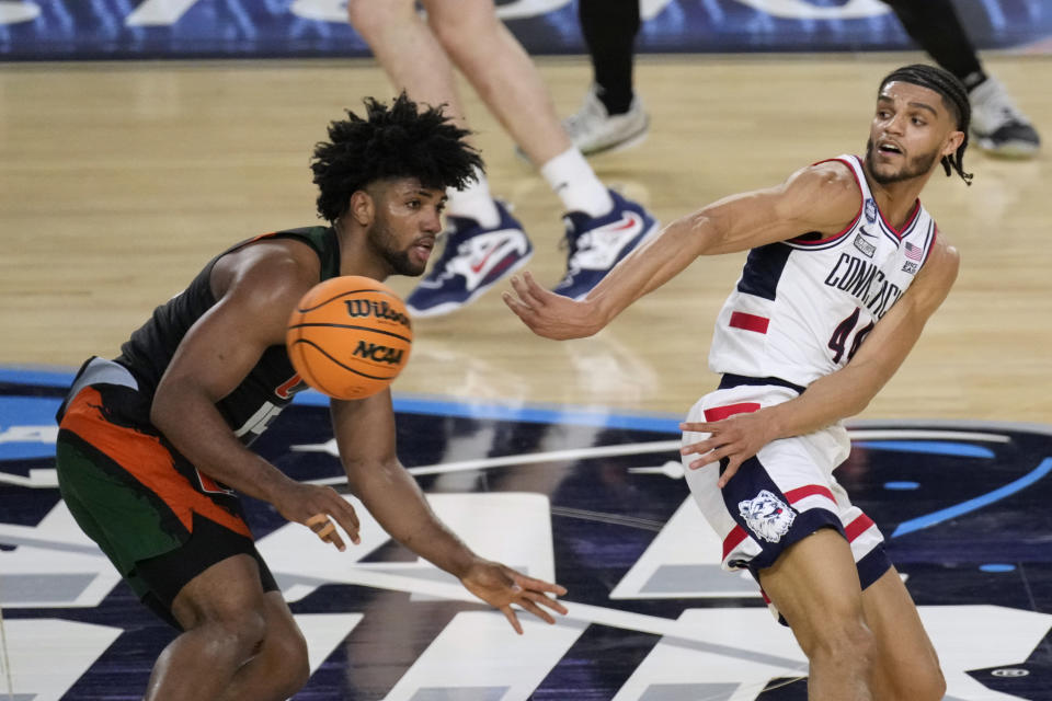 Connecticut guard Andre Jackson Jr. (44) passes around Miami forward Norchad Omier, left, during the second half of a Final Four college basketball game in the NCAA Tournament on Saturday, April 1, 2023, in Houston. (AP Photo/Godofredo A. Vasquez)