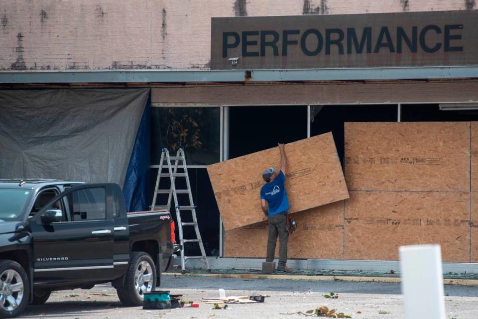 A worker boards up an auto body shop in Moss Point on Tuesday, June 20, 2023, after a tornado tore through the town on Monday.