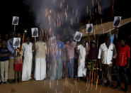 FILE - In this Jan. 20, 2021, file photo, villagers release firecrackers and hold placards featuring Vice President Kamala Harris after her inauguration, in Thulasendrapuram, the hometown of Harris' maternal grandfather, south of Chennai, Tamil Nadu state, India. (AP Photo/Aijaz Rahi, File)