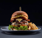 Not for the faint-hearted, this creation has a double patty, smoked cheese, beer battered onion rings, and two rashers of double smoked bacon. The chefs are challenging anyone who can finish the meal, which weighs in at 750 grams (with chips) at the Sports Bar all week from 27 May 2019. Photo: Supplied/The Star