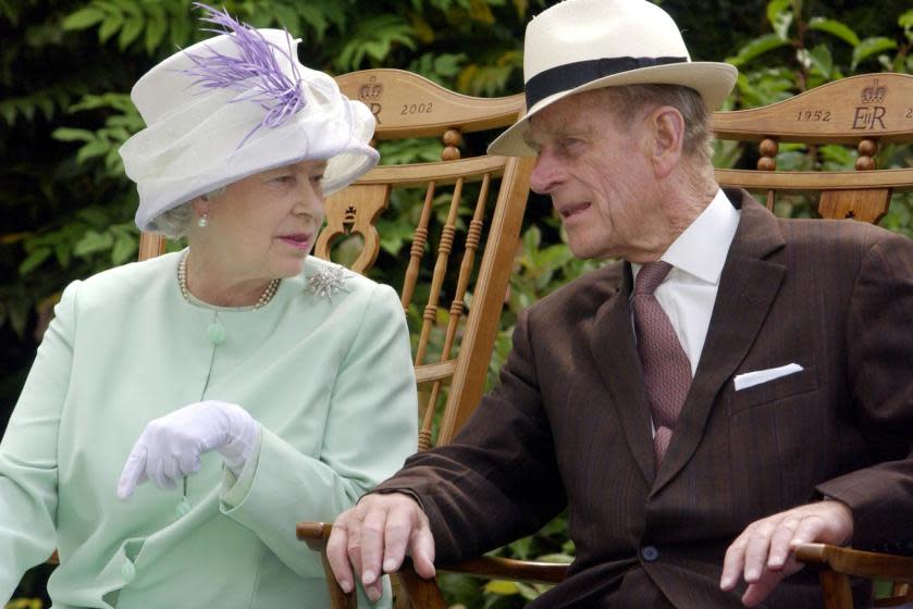 Queen Elizabeth II and Prince Philip chat during a musical performance in the Abbey Gardens in Suffolk in 2002.