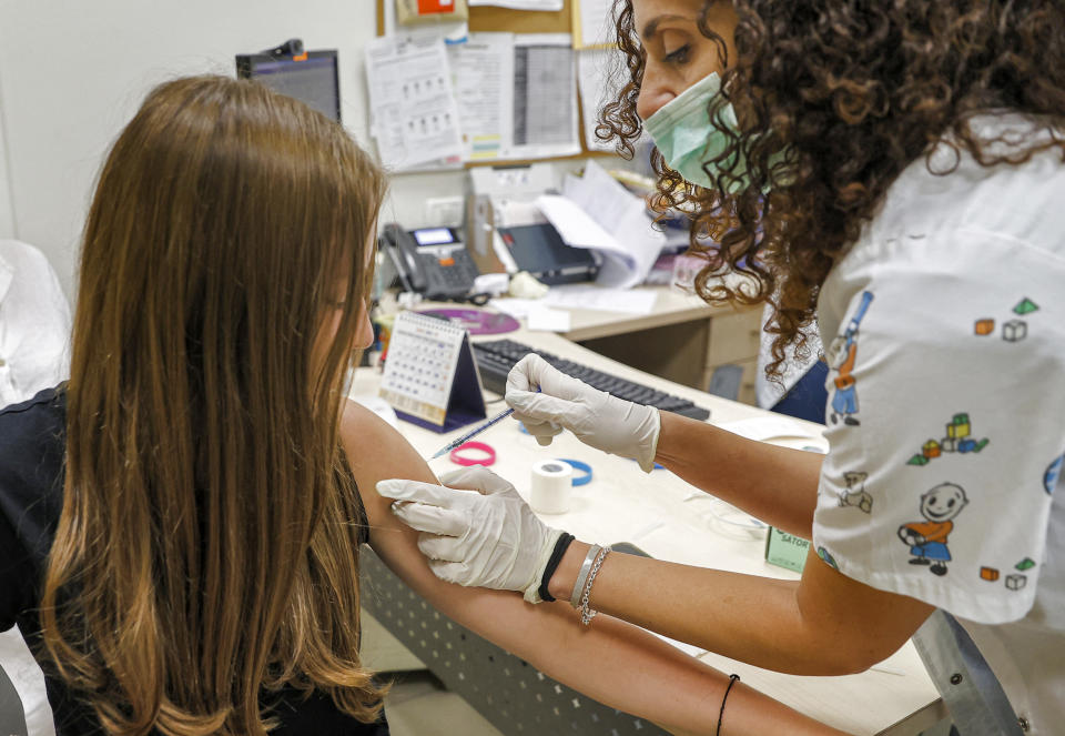 A teenage girl receives a dose of the Pfizer/BioNTech Covid-19 vaccine at the Clalit Healthcare Services in the Israeli city of Holon near Tel Aviv on June 21, 2021, as Israel begins coronavirus vaccination campaign for 12 to 15-year-olds. - Israel is now urging more 12- to 15-year-olds to be vaccinated, citing new outbreaks attributed to the more infectious Delta variant. (Photo by JACK GUEZ / AFP) (Photo by JACK GUEZ/AFP via Getty Images)