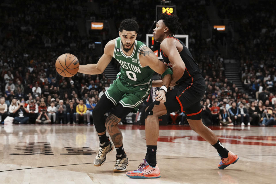 Toronto Raptors forward Scottie Barnes (4) defends against Boston Celtics forward Jayson Tatum (0) during the second half of an NBA basketball game, in Toronto, Monday, Dec. 5, 2022. (Chris Young/The Canadian Press via AP)