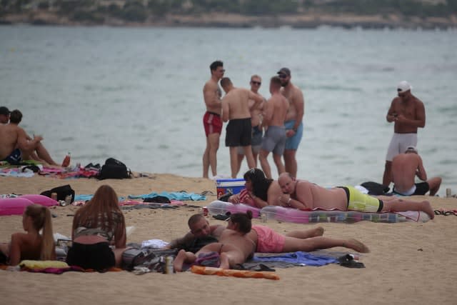 Tourists enjoy the beach on the island of Mallorca