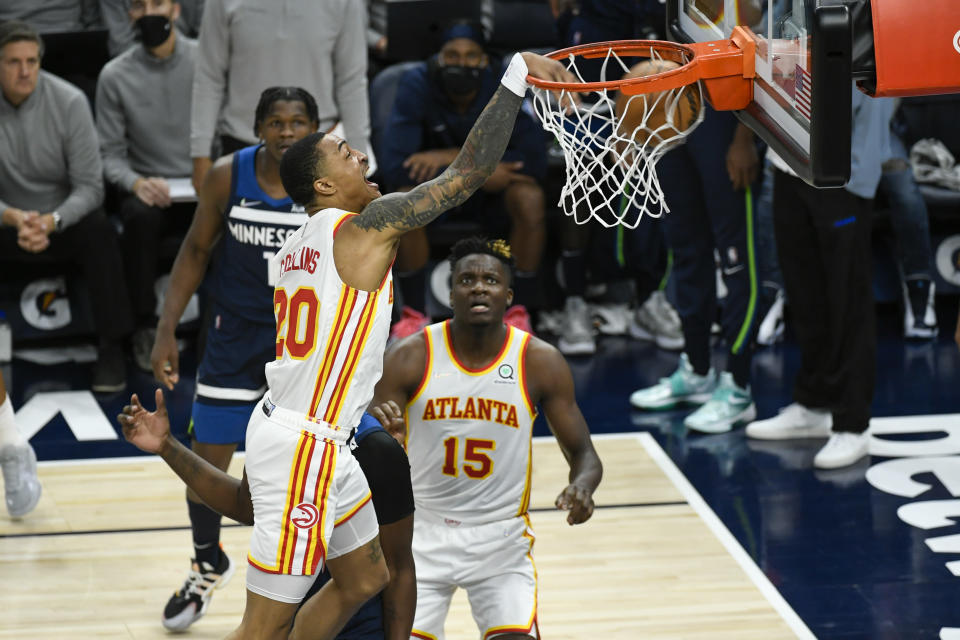 Atlanta Hawks forward John Collins dunks against the Minnesota Timberwolves as Hawks center Clint Capela (15) watches during the second half of an NBA basketball game Monday, Dec. 6, 2021, in Minneapolis. (AP Photo/Craig Lassig)