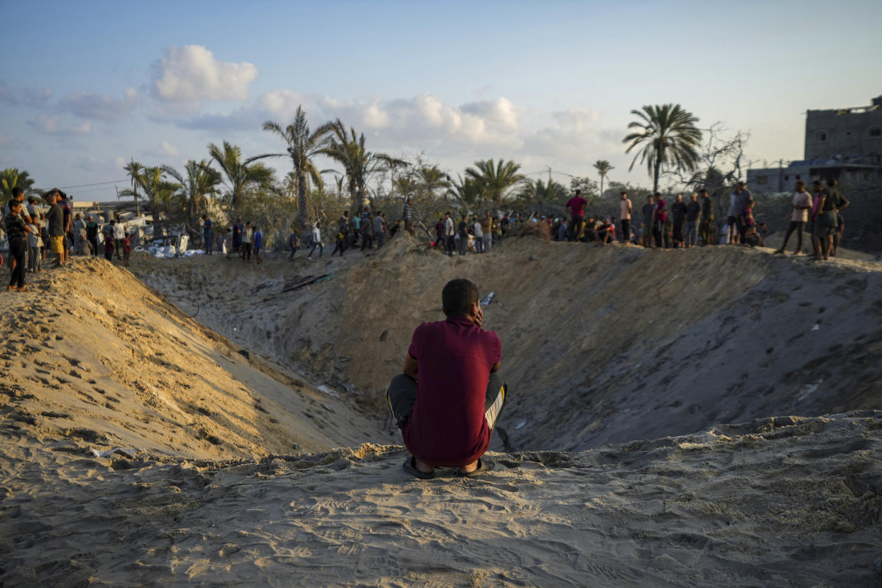 Palestinians look at the destruction after an Israeli airstrike on a crowded tent camp housing Palestinians displaced by the war in Muwasi, Gaza Strip, Tuesday, Sept. 10, 2024. An Israeli strike killed at least 40 people and wounded 60 others early Tuesday, Palestinian officials said. Israel said it targeted "significant" Hamas militants, allegations denied by the militant group. (AP Photo/Abdel Kareem Hana)