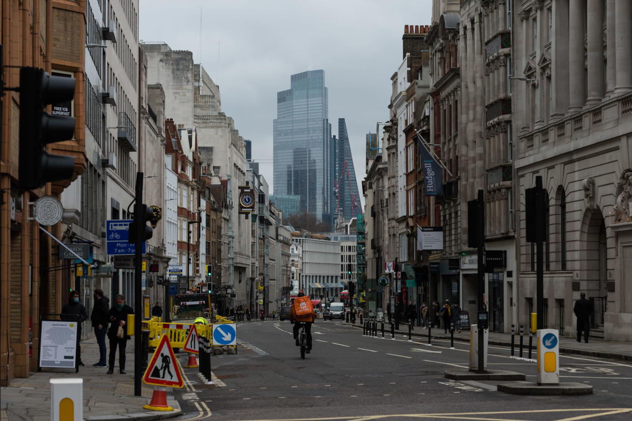 LONDON, UNITED KINGDOM - MARCH 04, 2021: A delivery rider cycles through empty street in the City of London a day after the announcement of corporation tax increase from 19% to 25% for the most profitable companies from April 2023 in Rishi Sunak's Budget, on 04 March, 2021 in London, England. The Chancellor's tax and spending plans focus on measures to support the UK's economic recovery from the slump caused by the coronavirus pandemic with furlough scheme extended until September and budget deficit expected to reach a record of £355bn this year.- PHOTOGRAPH BY Wiktor Szymanowicz / Barcroft Studios / Future Publishing (Photo credit should read Wiktor Szymanowicz/Barcroft Media via Getty Images)