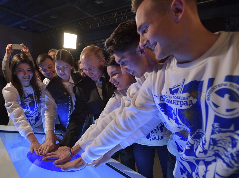 FILE - Russian President Vladimir Putin, centre, and participants of Volunteers of Victory Russian Public Movement visit the Interactive Museum "Russia – My History" in Volgograd, Russia, Friday, Feb. 2, 2018. In Russia, history has long become a propaganda tool used to advance the Kremlin's political goals. In an effort to rally people around the flag, the authorities have sought to magnify the country's past victories while glossing over the more sordid chapters of its history. (Alexei Druzhinin, Sputnik, Kremlin Pool Photo via AP, File)