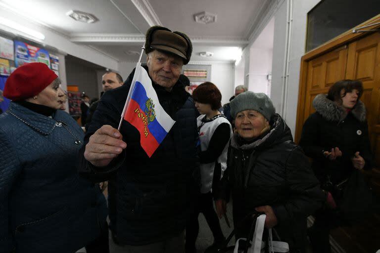 Votantes prorrusos en un colegio electoral durante las elecciones presidenciales de Rusia en Donetsk, Ucrania controlada por Rusia.(Photo by STRINGER / AFP)